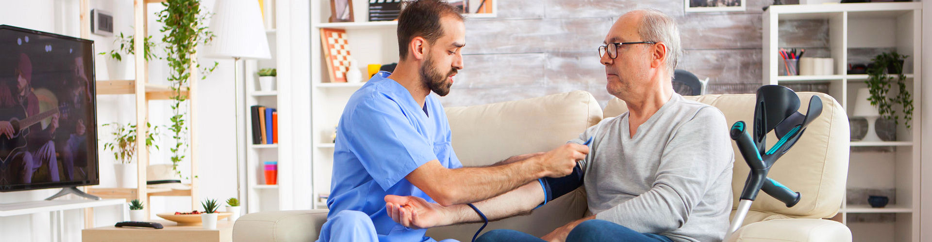 middle aged man checking the blood pressure of an elderly man